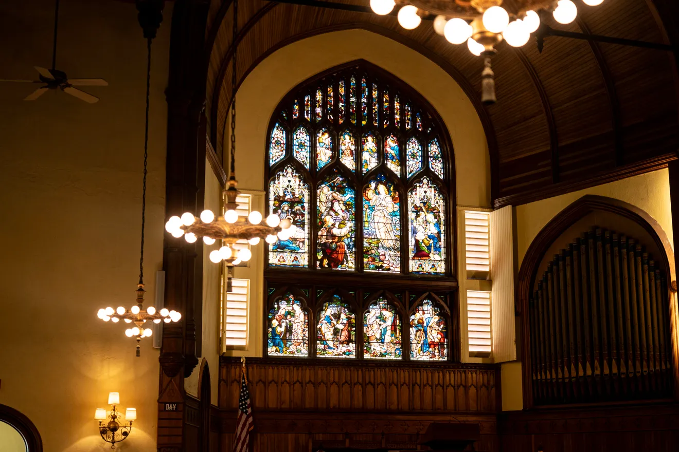 The sanctuary interior with its great stained-glass window and organ pipes