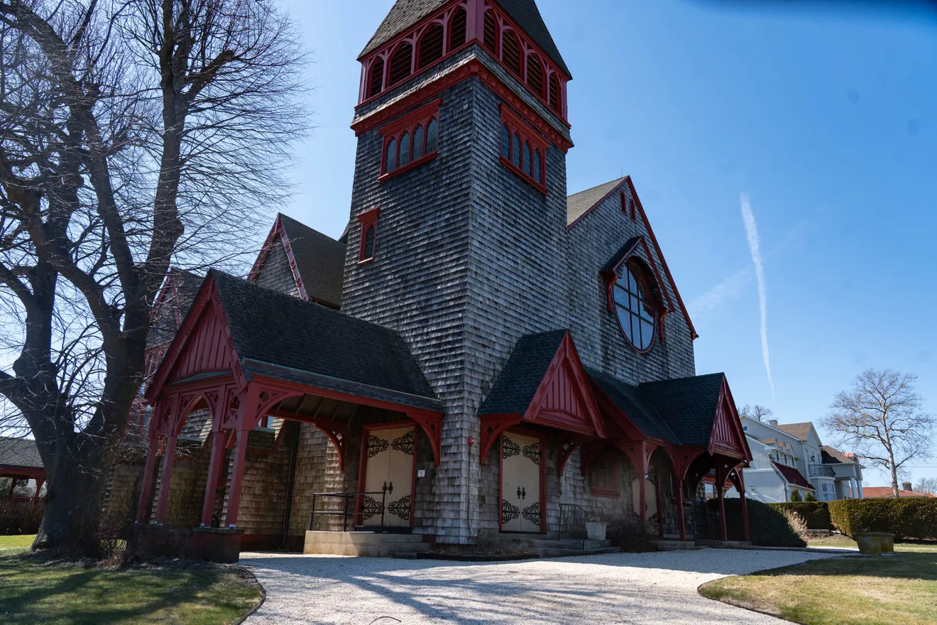 The shingle-style church exterior with its red porte-cochere